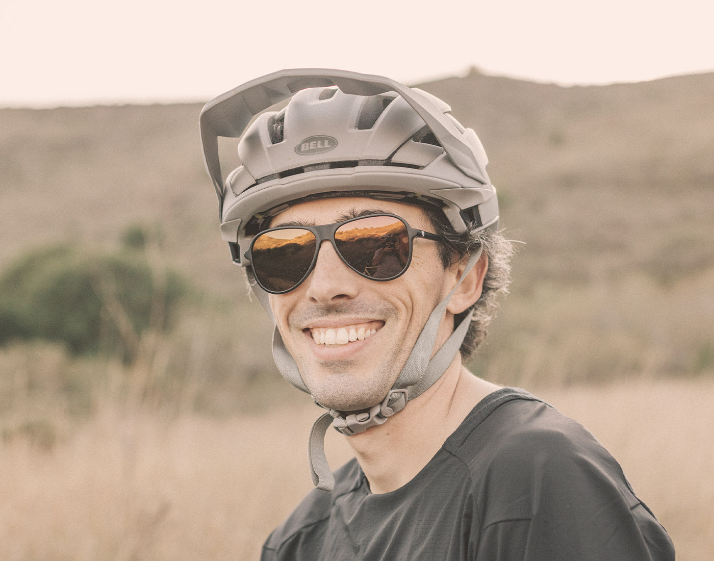 guy in bike helmet smiling wearing sunski foxtrot sunglasses