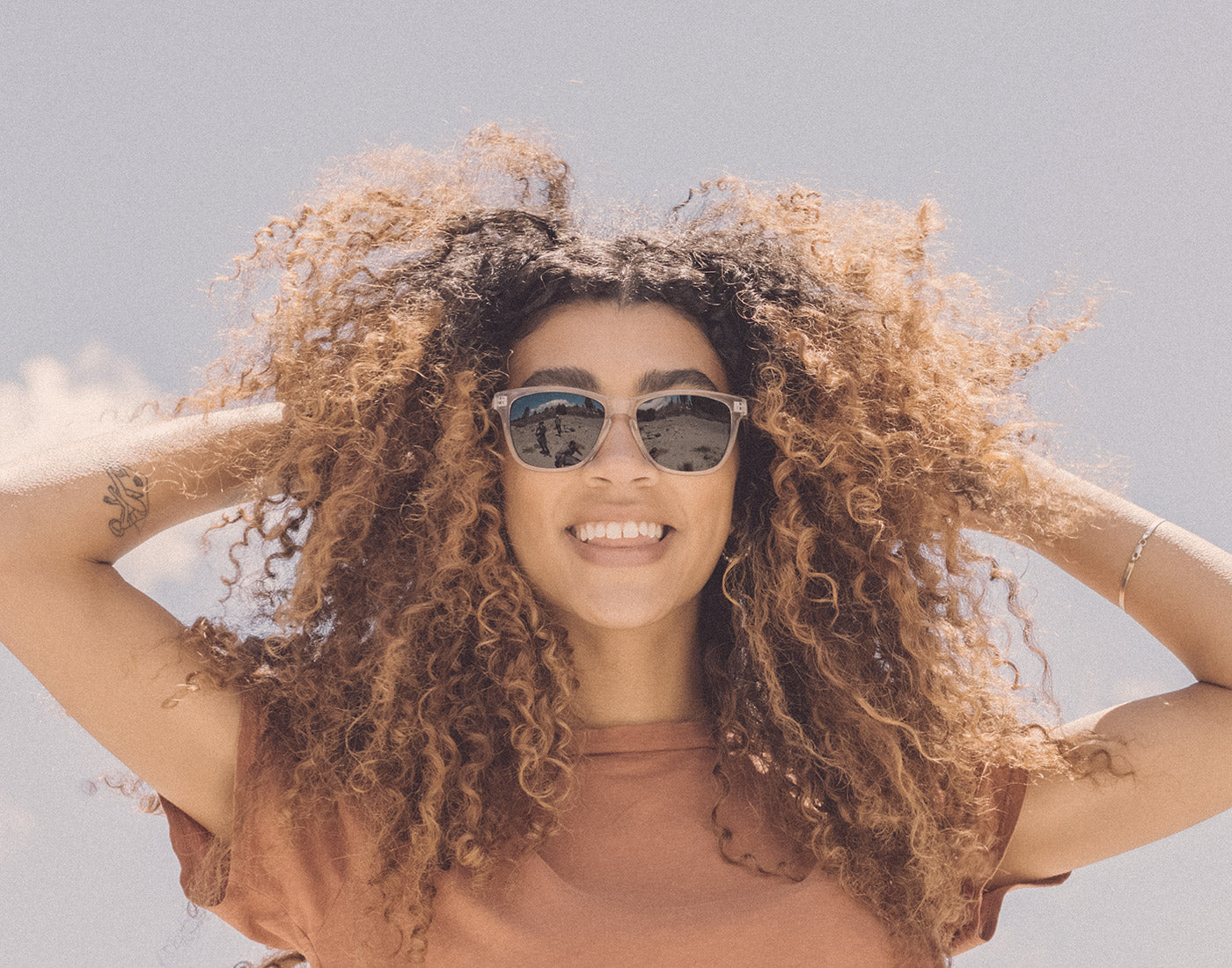 girl playing with hair wearing sunski headland sunglasses