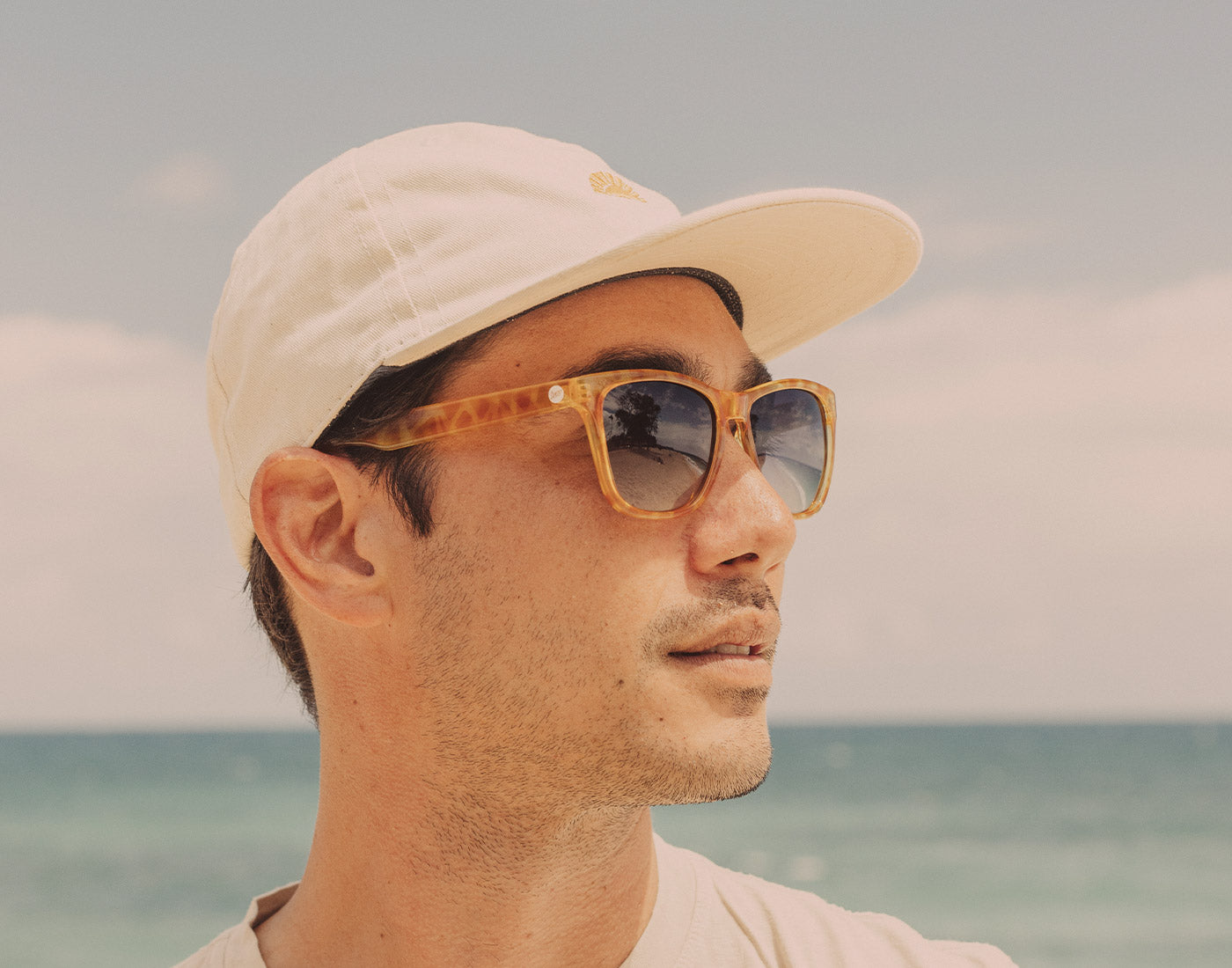 profile of guy in hat wearing sunski madrona sunglasses