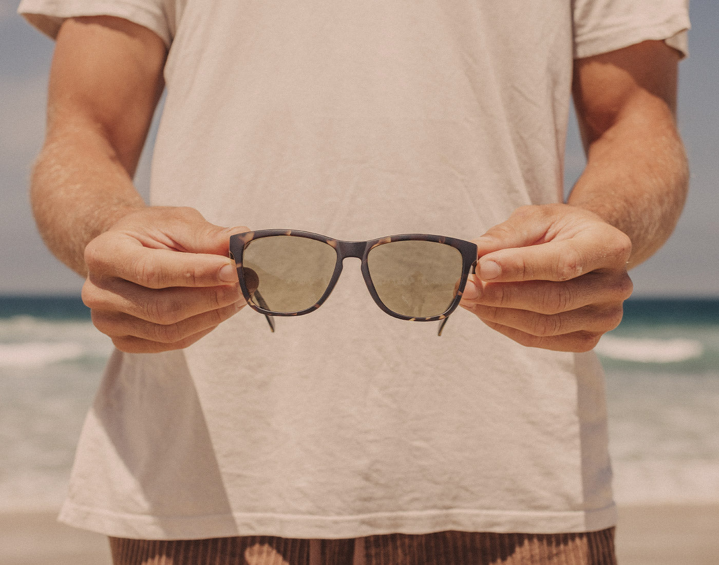 hands holding sunski madrona sunglasses unfolded