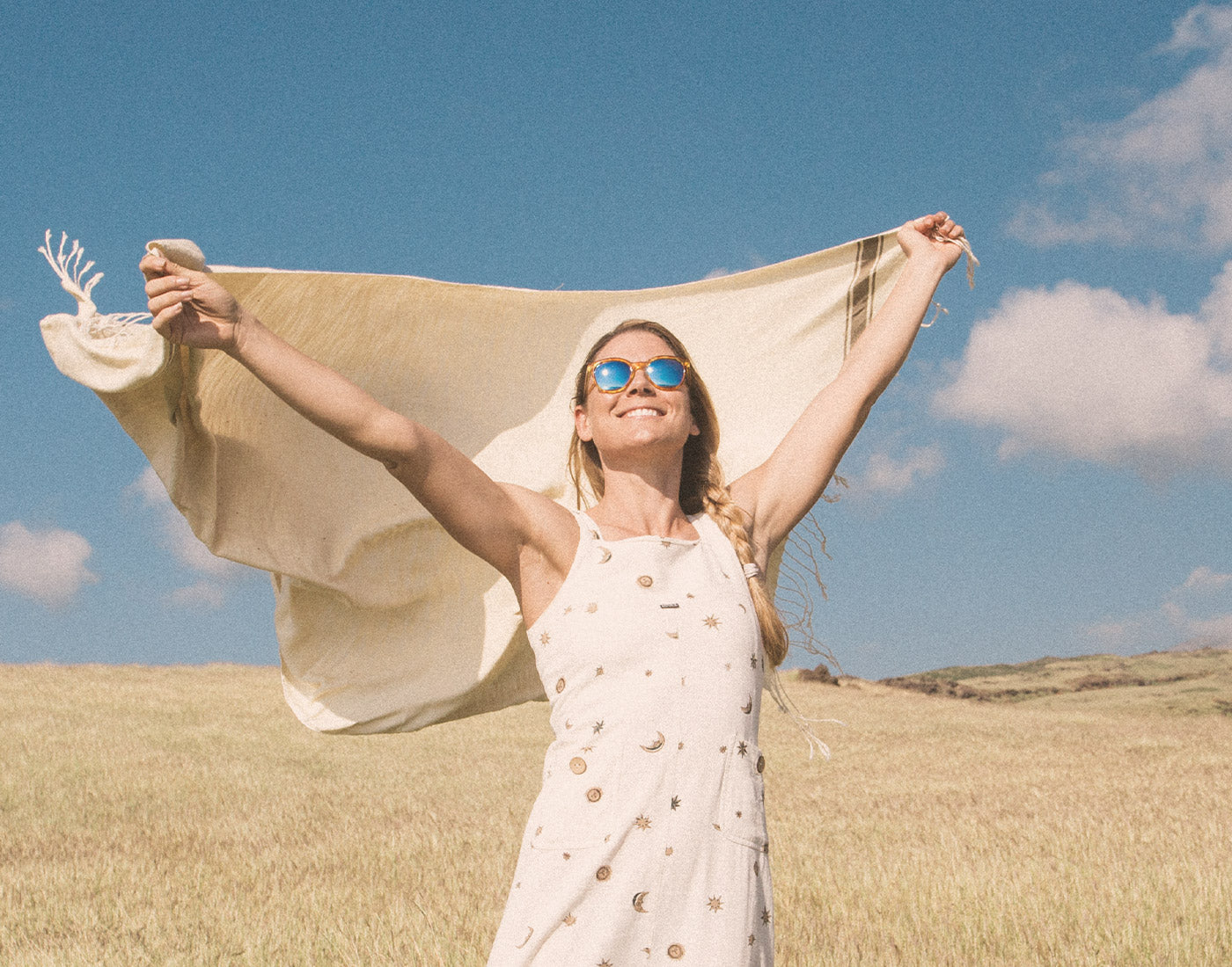 girl holding blanket in the wind wearing sunski makani sunglasses 
