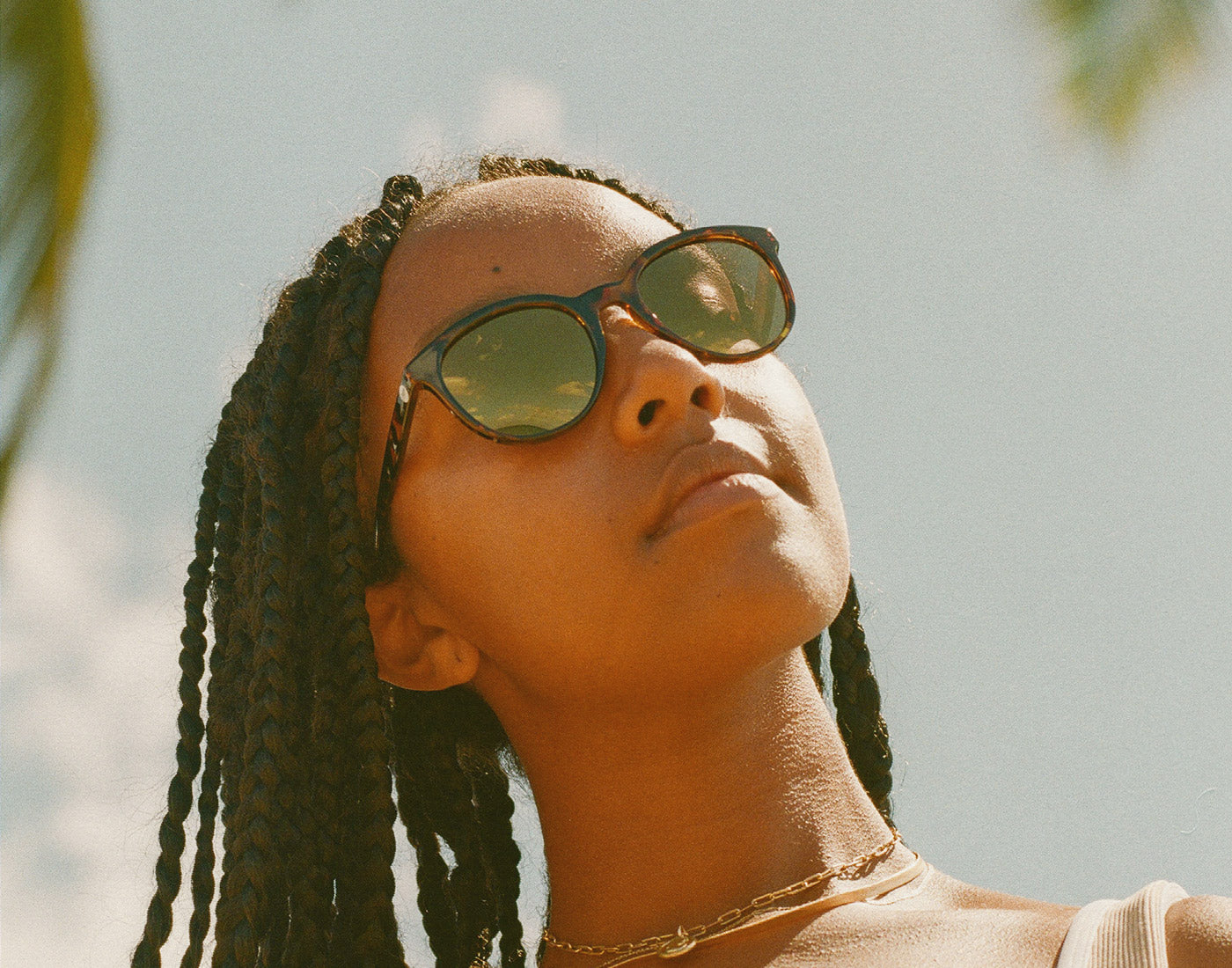 woman looking up toward the sun wearing sunski makani sunglasses
