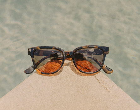 sunski miho sunglasses on side of a pool 