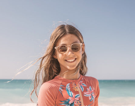 girl on the beach wearing sunski mini dipsea sunglasses
