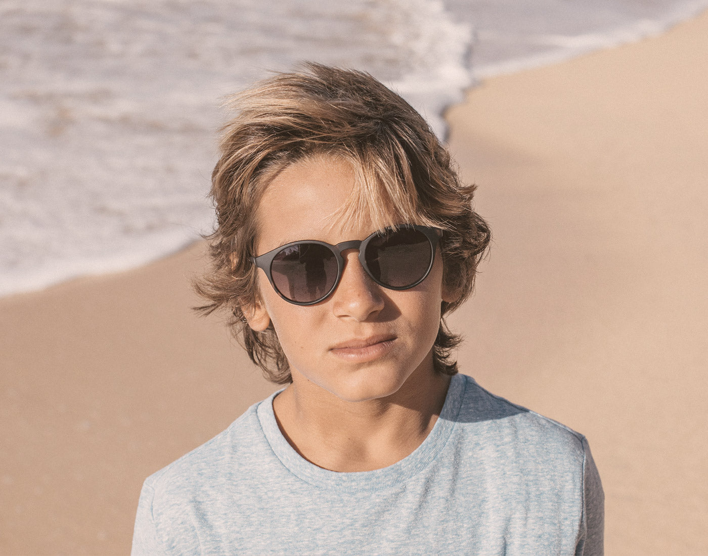 boy on the beach wearing sunski mini dipsea sunglasses