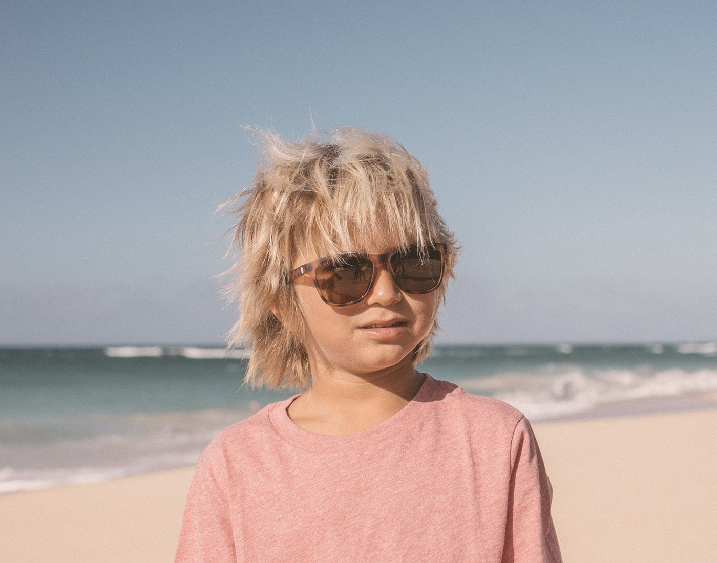 boy on the beach wearing sunski mini madrona sunglasses
