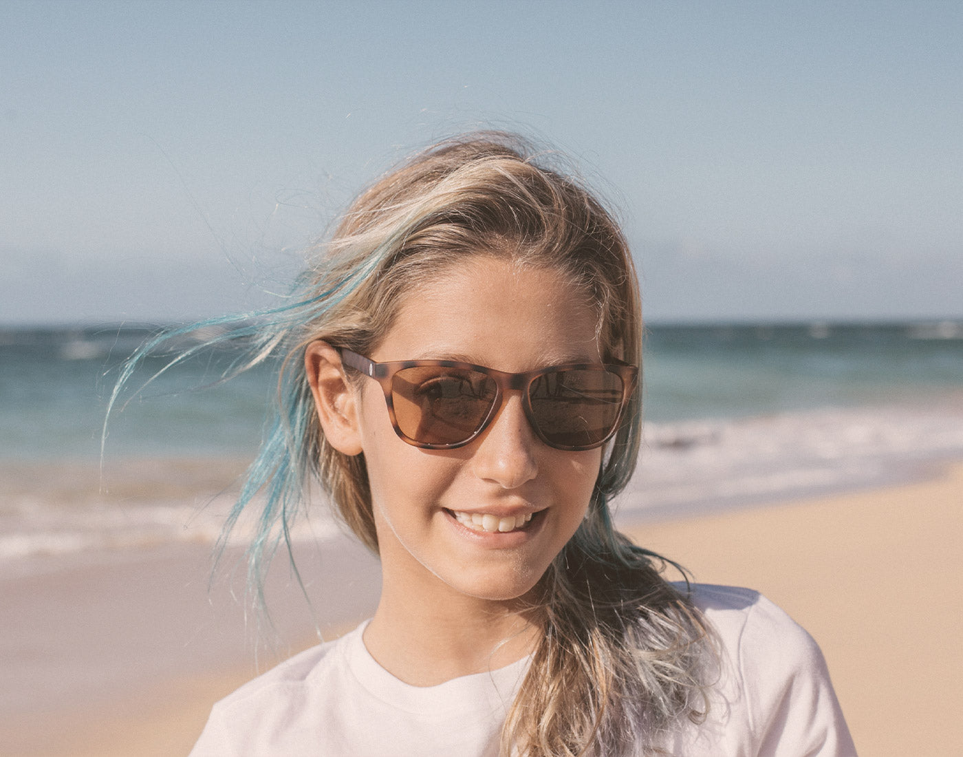 girl on the beach wearing sunski mini madrona sunglasses