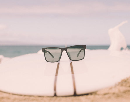 sunski puerto sunglasses on a surfboard