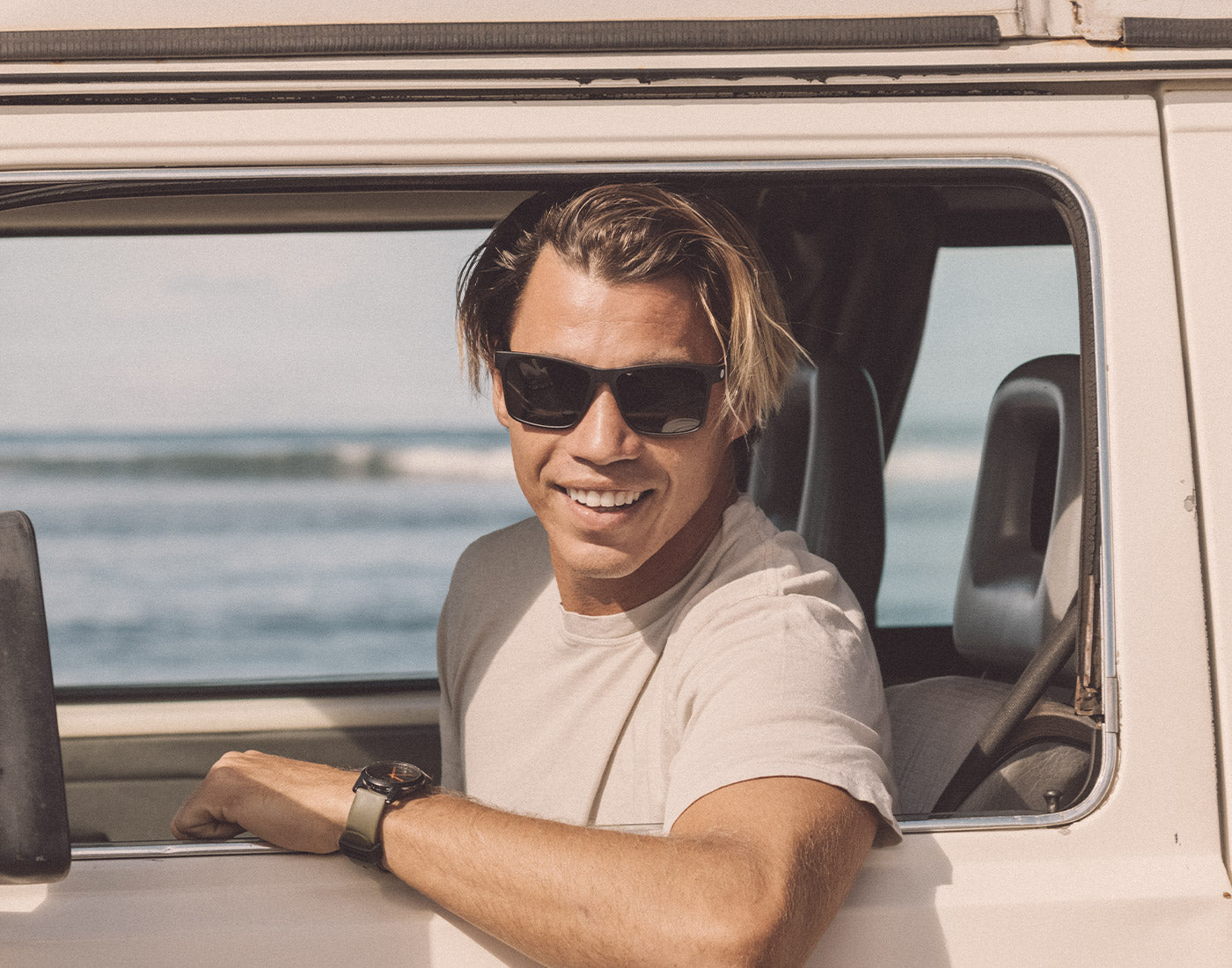 guy leaning out car window wearing sunski puerto sunglasses