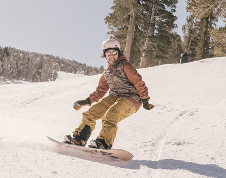 girl snowboarding wearing sunski tera sunglasses