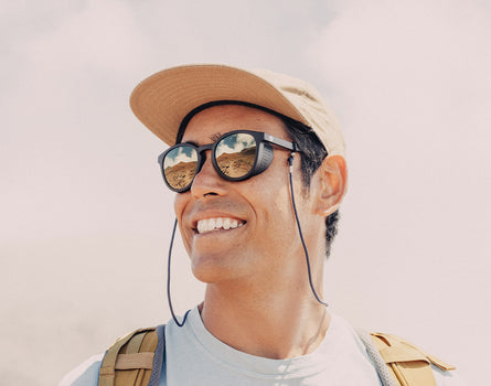 guy in a hat smiling wearing sunski tera sunglasses