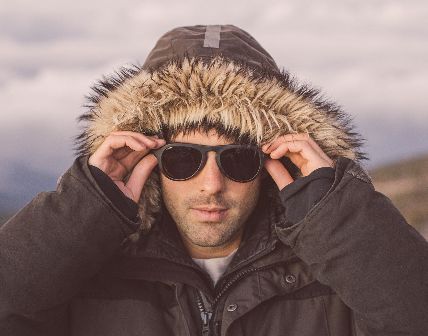 man in a fure hood wearing sunski treeline sunglasses