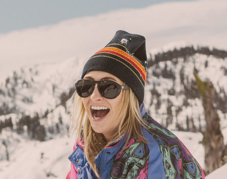 girl laughing in a beanie wearing sunski treeline sunglasses