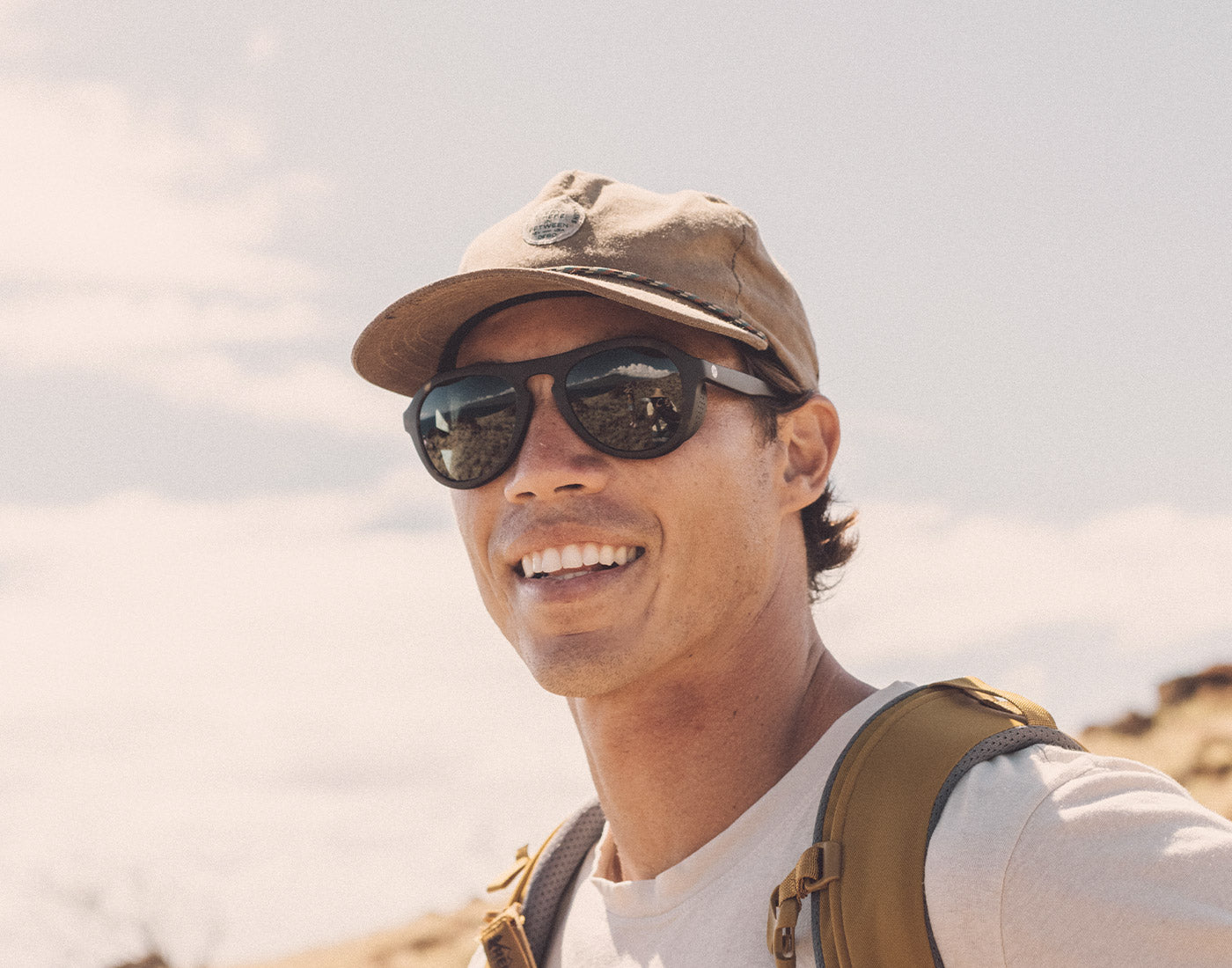 guy hiking in a hat wearing sunski treeline sunglasses