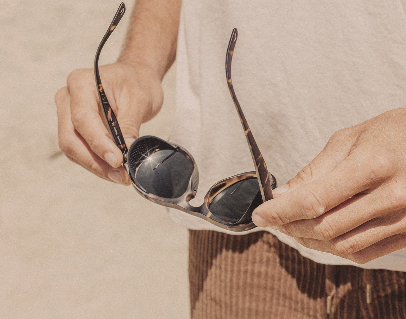 hands holding sunski treeline sunglasses