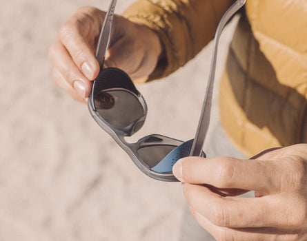 man holding sunski treeline sunglasses