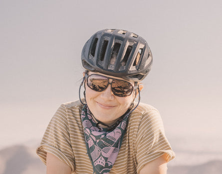 girl in a bike helmet wearing sunski velo sunglasses