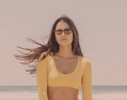 girl in a yellow bathing suit wearing sunski ventant sunglasses