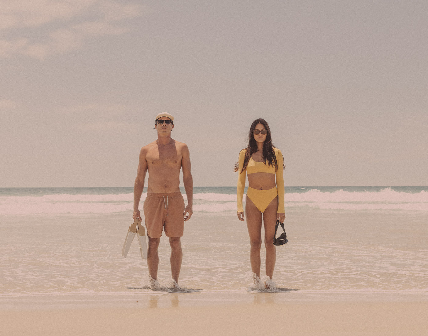 guy and girl standing the ocean wearing sunski ventana sunglasses