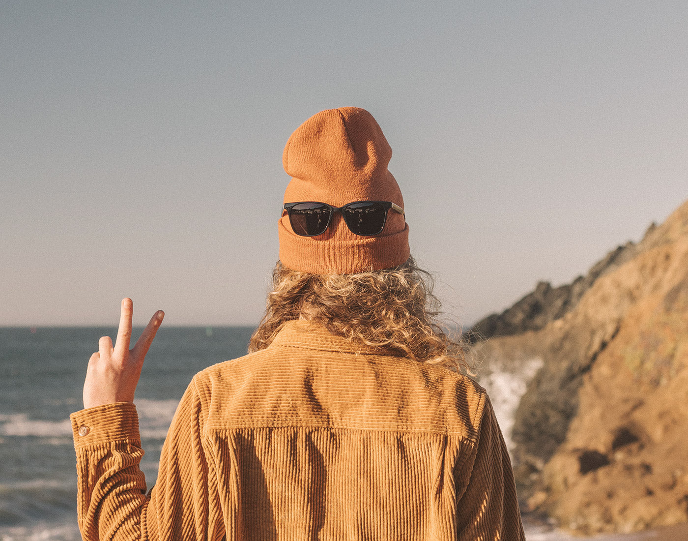 girl with sunski ventana sunglasses on back of head throwing a peace sign