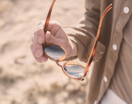 someone holding sunski yuba sunglasses facing down