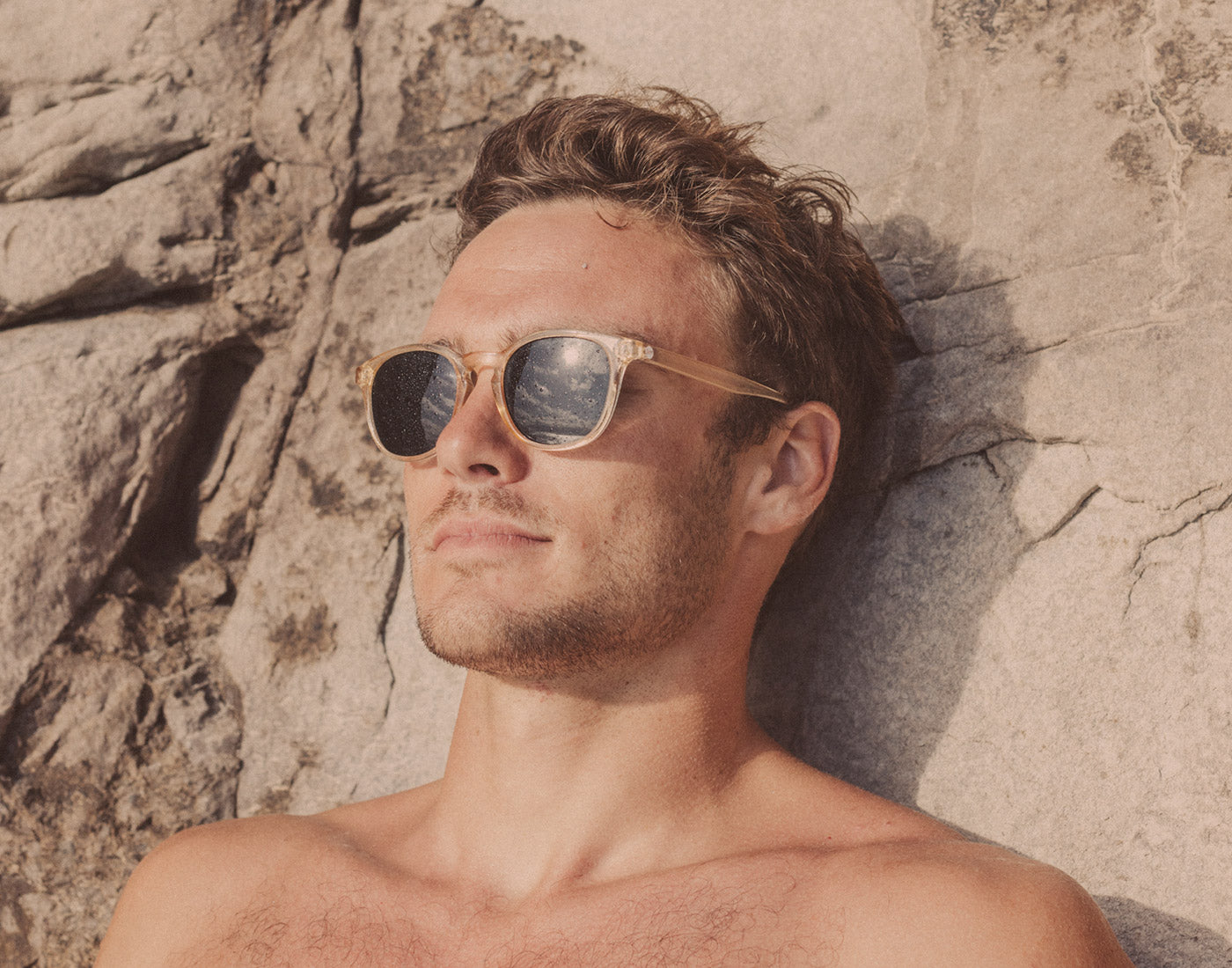 guy leaning on rock wearing sunski yuba sunglasses
