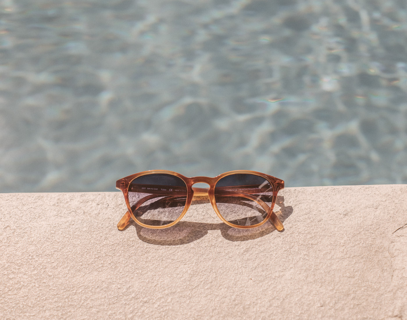 sunski yuba sunglasses on edge of pool
