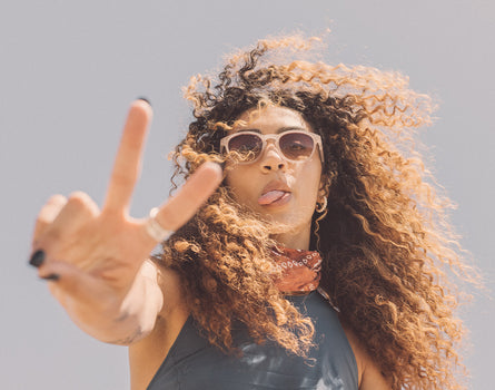 girl sticking tongue out with peace sign wearing sunski yuba sunglasses
