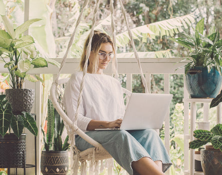 girl sitting on swing seat using computer wearing sunski yuba bluelight glasses