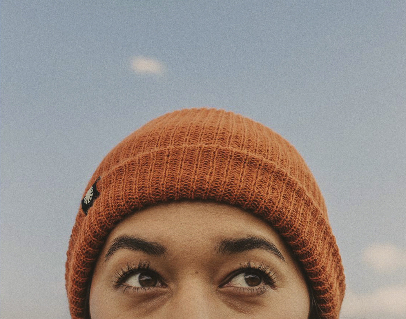 close up of persons eyes wearing sunski shoulder season beanie