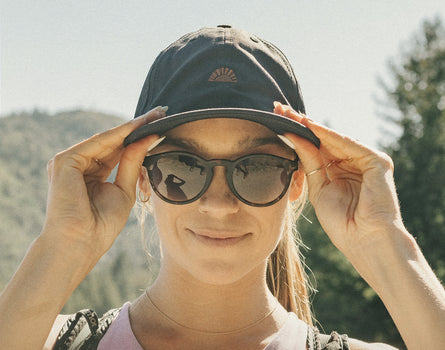 front angle of girl wearing sunski sunburst hat and sunglasses