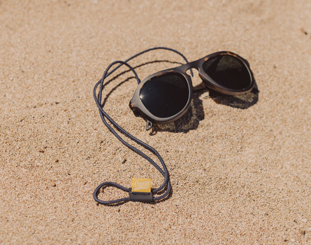 sunski sunglasses retainer on a pair of sunglasses on the sand