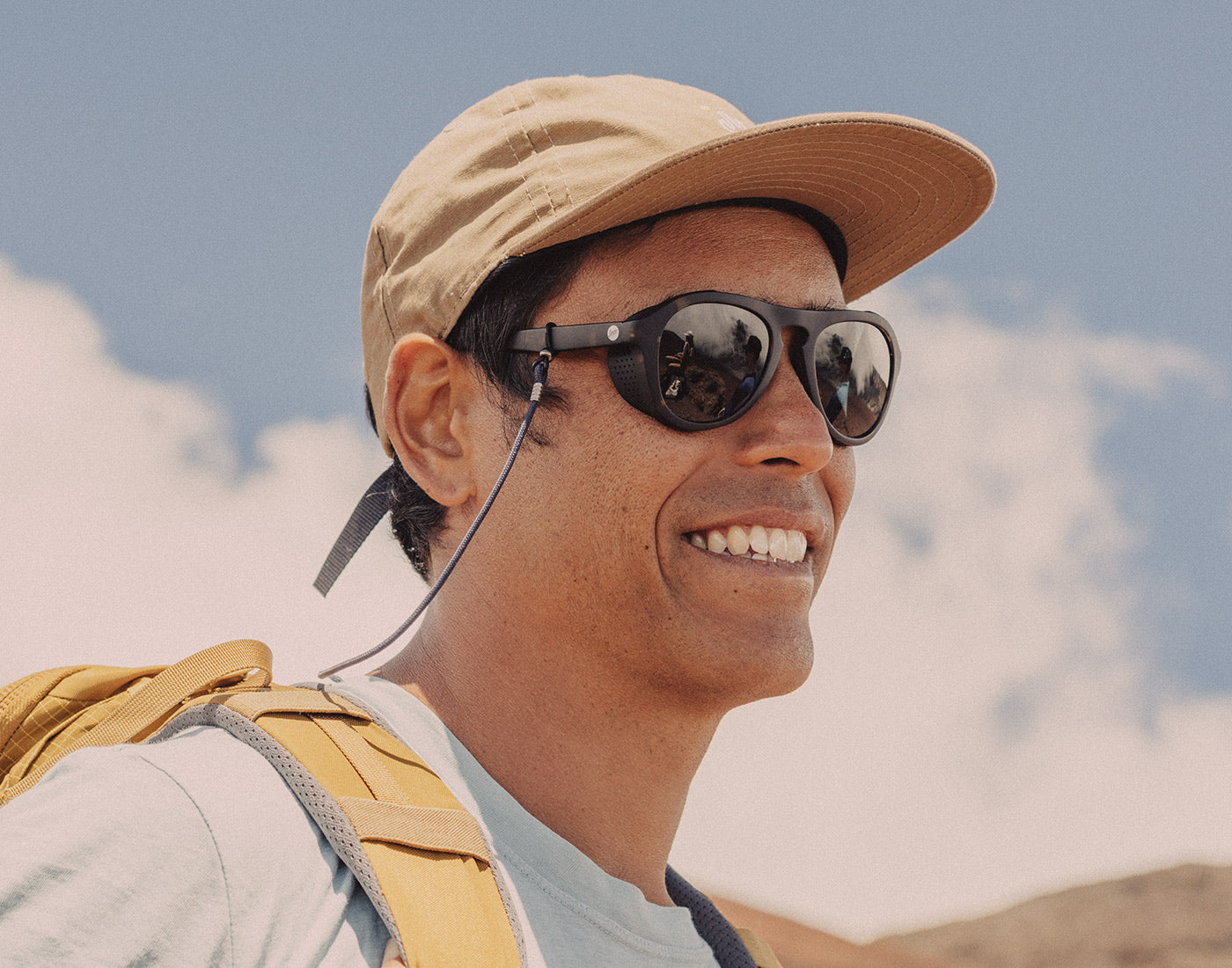 man wearing sunski sunglasses retainer on a hike