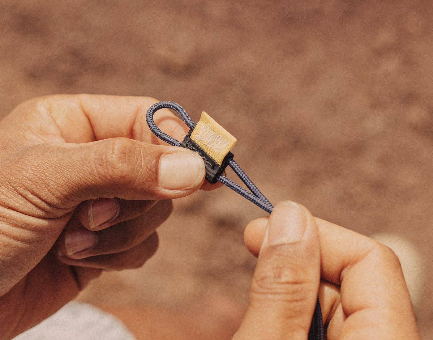 hands adjusting strap on sunski sunglasses retainer