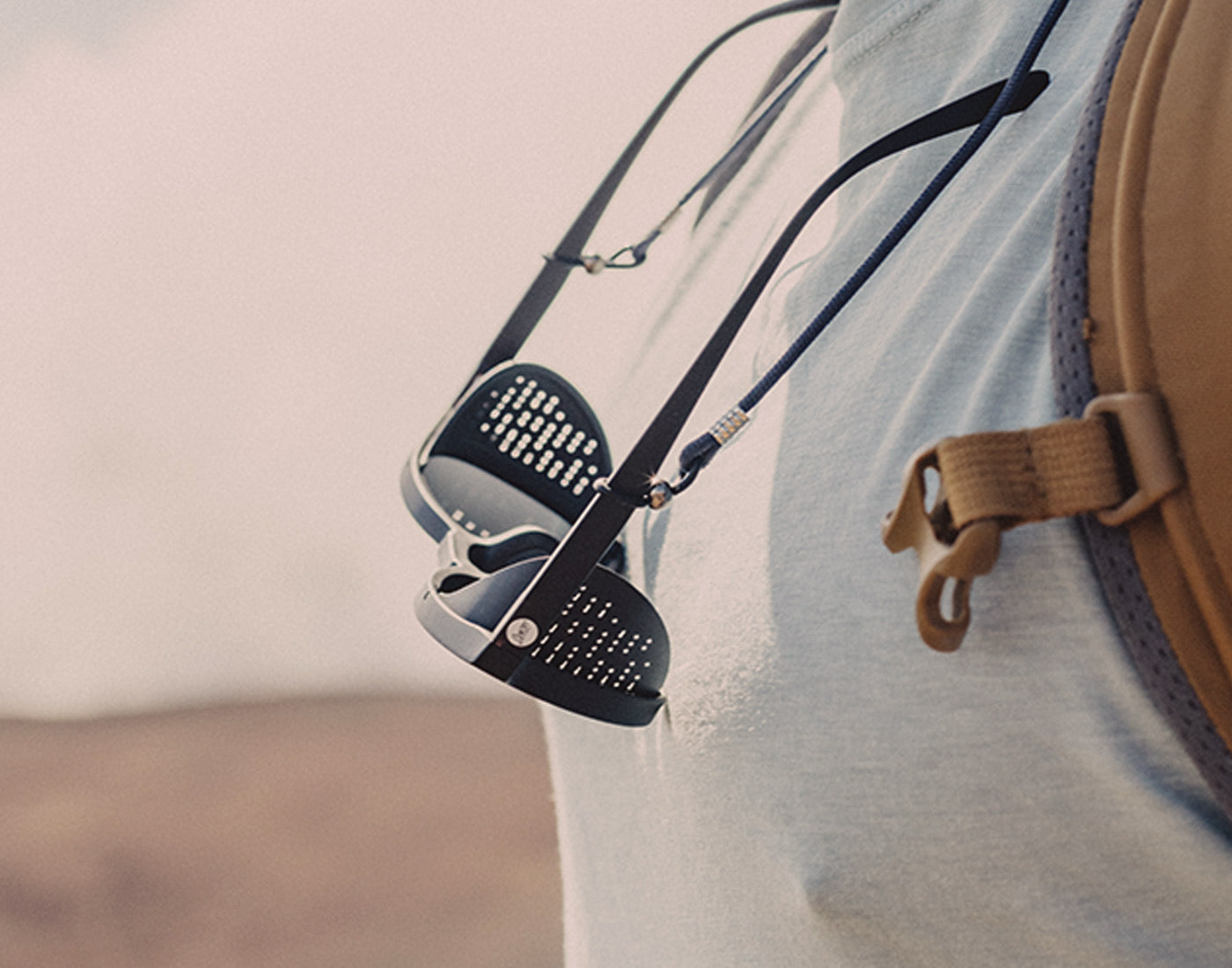 sunski sunglasses retailer holding sunglasses on someone's neck