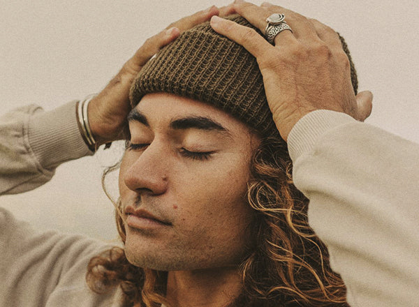 guy with hands on head wearing sunski winter sun beanie