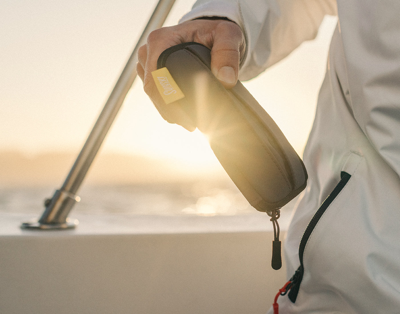 someone holding sunski zipper case in the sun